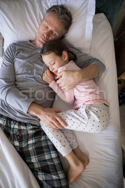 Father and daughter sleeping together on bed in bedroom Stock photo © wavebreak_media