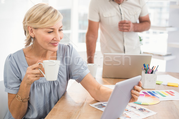 Stock photo: Smiling businesswoman holding a tablet