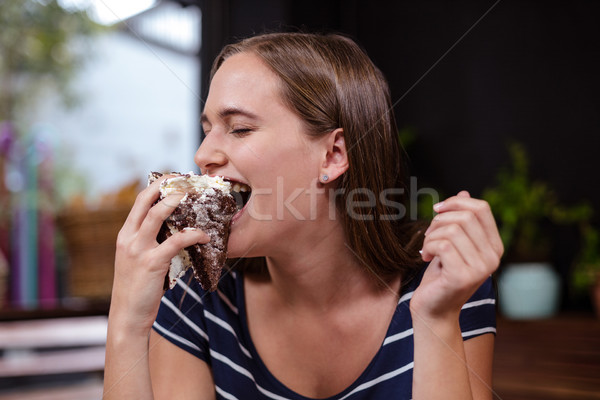 Pretty woman eating piece of cake with hand Stock photo © wavebreak_media