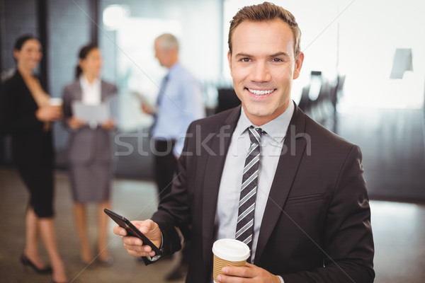 Portré üzletember tart mobiltelefon csésze kávé Stock fotó © wavebreak_media