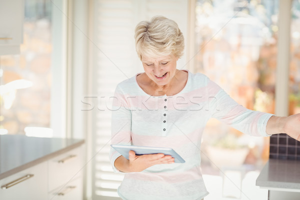 Feliz senior mulher digital comprimido cozinha Foto stock © wavebreak_media