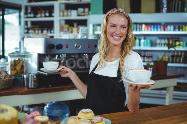 Stock photo: Smiling waitress offering cup of coffee