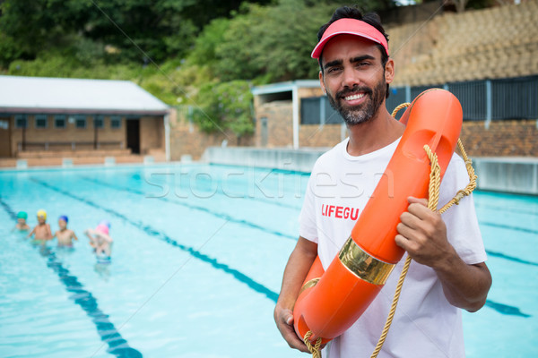 Lifeguard standing with lifebuoy near poolside Stock photo © wavebreak_media