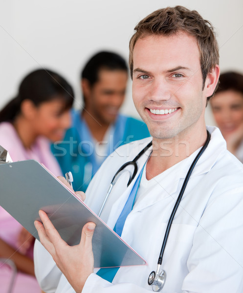 Jungen männlichen Arzt lächelnd Kamera Team Lächeln Stock foto © wavebreak_media