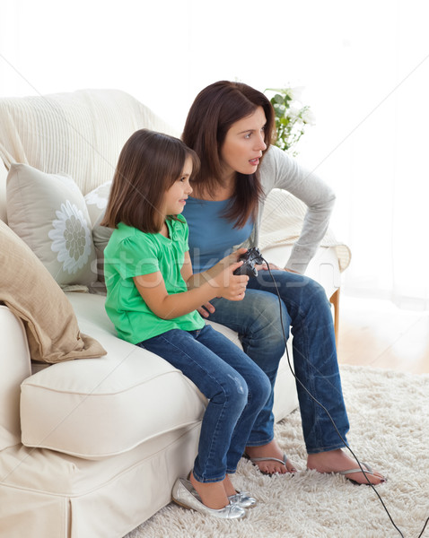 Concentrated mom and daughter playing video games together in the living room Stock photo © wavebreak_media