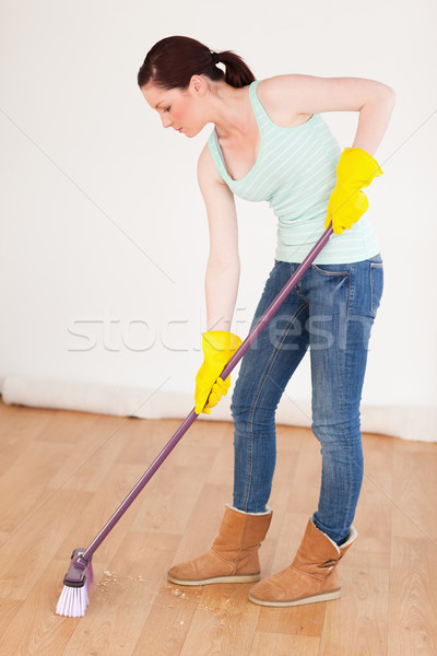 Beautiful red-haired woman sweeping the floor at home Stock photo © wavebreak_media