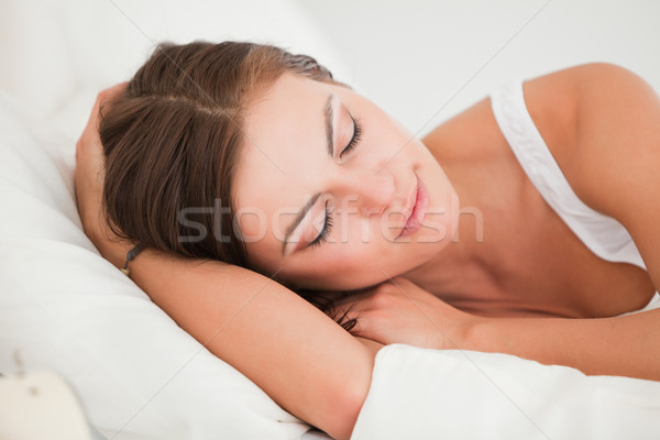 Young woman sleeping in her bed against a white background Stock photo © wavebreak_media