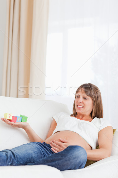 Attractive pregnant woman playing with wooden blocks and having the word 'girl' written on her hand  Stock photo © wavebreak_media