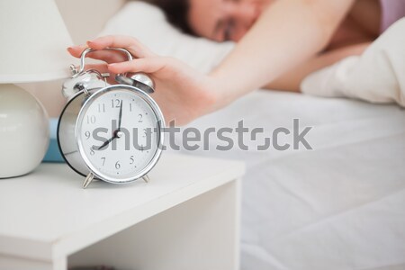 Portrait of a blonde woman awaken by an alarmclock with the camera focus on the object Stock photo © wavebreak_media