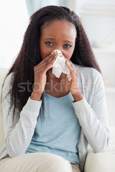 Close up of young woman on couch blowing her nose Stock photo © wavebreak_media