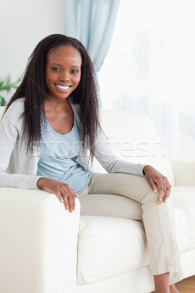 Smiling woman on sofa with legs folded Stock photo © wavebreak_media