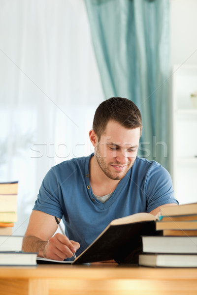 Smiling male student reviewing his subject material Stock photo © wavebreak_media