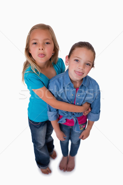 Stock photo: Portrait of girls sticking out their tongues against a white background