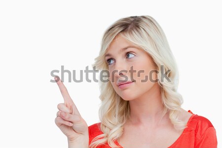 Woman pointing something in the air with her finger against a white background Stock photo © wavebreak_media