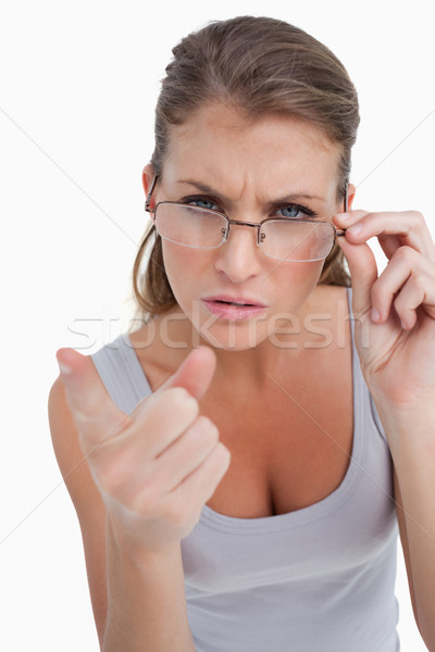 Portrait of a serious woman with glasses pointing at the viewer against a white background Stock photo © wavebreak_media