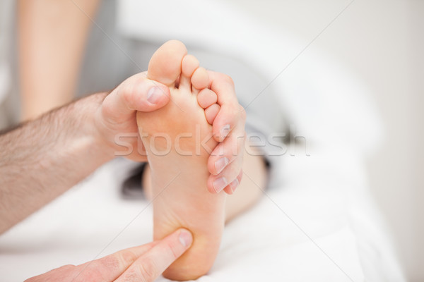 Doctor using his fingertips to touch the ball of a foot in a room Stock photo © wavebreak_media