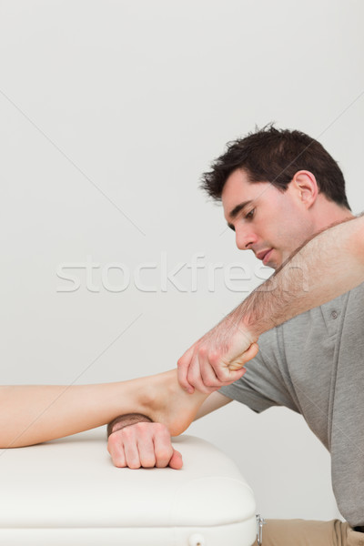 Serious practitioner holding the foot of a patient indoors Stock photo © wavebreak_media