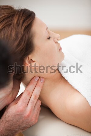 Doctor massaging the neck of woman while holding her head in a room Stock photo © wavebreak_media