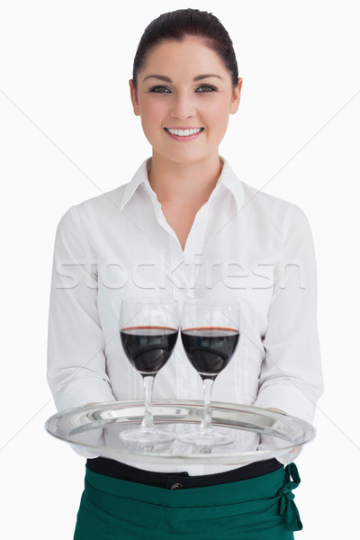 Smiling woman holding a silver tray with glasses of red wine Stock photo © wavebreak_media