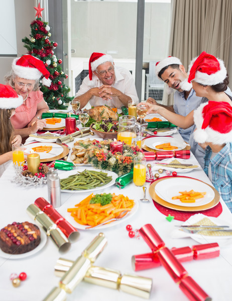 Happy family in santas hats enjoying Christmas dinner Stock photo © wavebreak_media