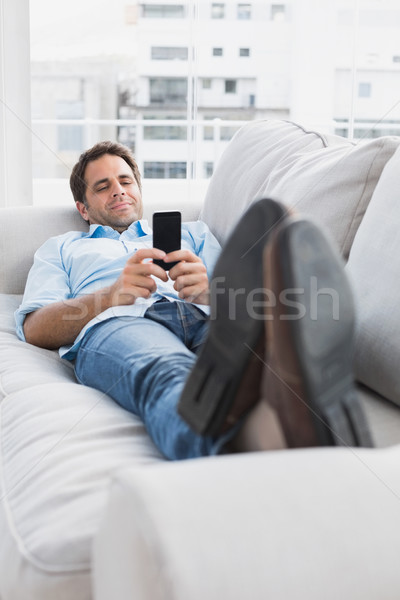 Boldog férfi kanapé küldés szöveg otthon Stock fotó © wavebreak_media