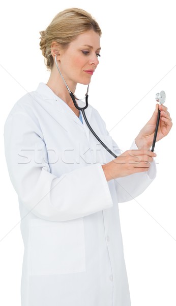 Blonde doctor in lab coat listening with stethoscope Stock photo © wavebreak_media