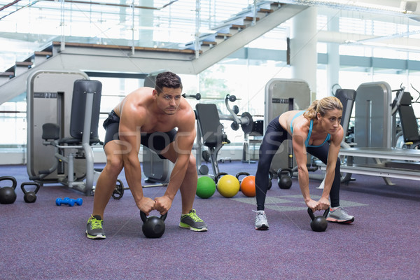 Bodybuilding man and woman lifting kettlebells in a squat  Stock photo © wavebreak_media