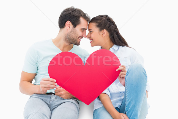 Cute couple sitting holding red heart Stock photo © wavebreak_media