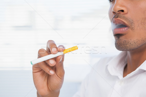Businessman smoking an electronic cigarette Stock photo © wavebreak_media