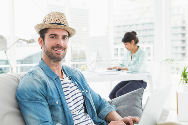 Smiling businessman typing on laptop on couch Stock photo © wavebreak_media