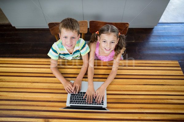 Smiling siblings using laptop in kitchen Stock photo © wavebreak_media