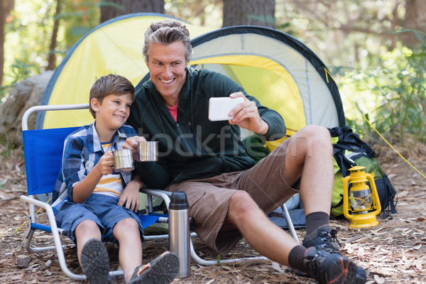 Happy father and son taking selfie while having hot drink in forest Stock photo © wavebreak_media