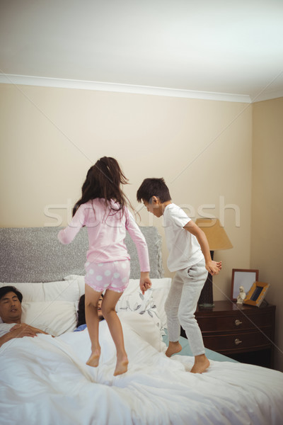 Siblings jumping on bed in bedroom Stock photo © wavebreak_media