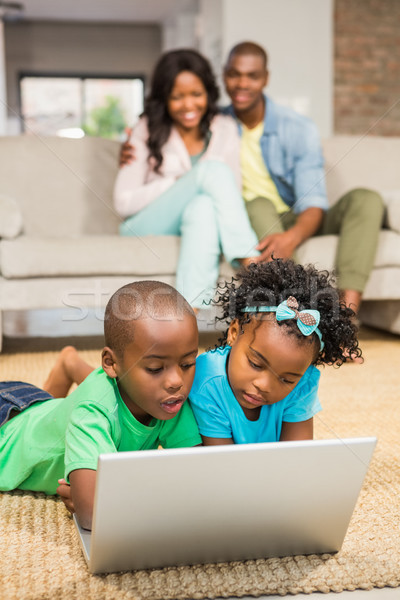 Foto stock: Feliz · irmãos · piso · usando · laptop · sala · de · estar · menina