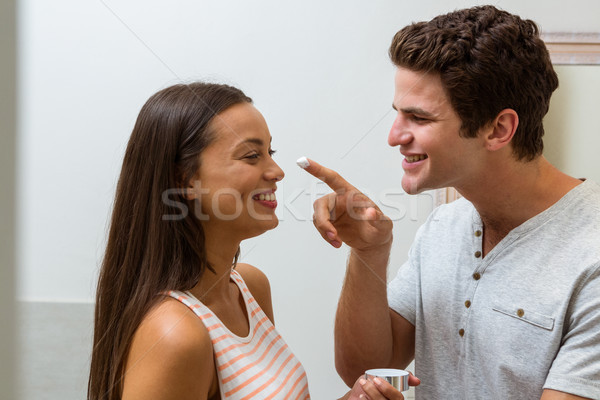 Playful man applying moisturizer on woman's nose Stock photo © wavebreak_media