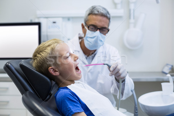 Dentist examining a young patient with tools  Stock photo © wavebreak_media