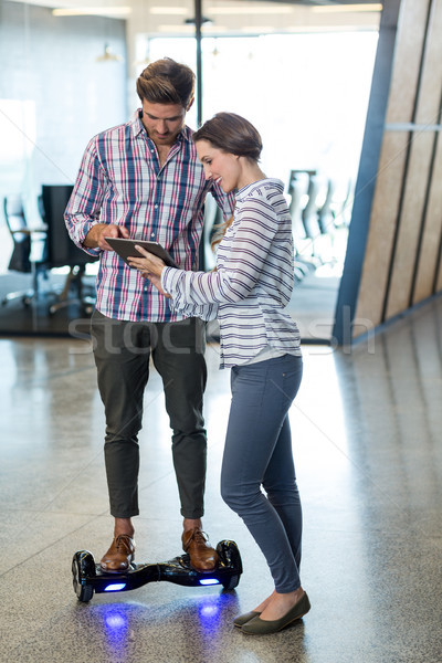 Man on hoverboard using digital tablet with colleagues Stock photo © wavebreak_media