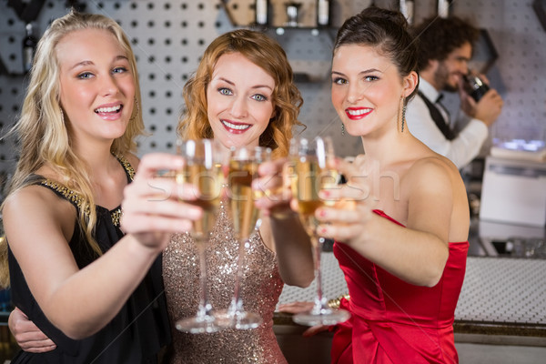 Three smiling friend showing glass of champagne Stock photo © wavebreak_media