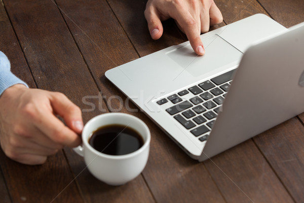 Człowiek za pomocą laptopa kubek kawy drewniany stół komputera Zdjęcia stock © wavebreak_media