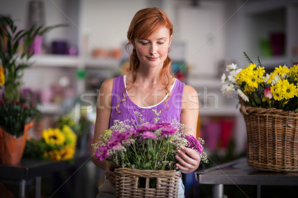 Stock photo: Female florist holding basket of flowers