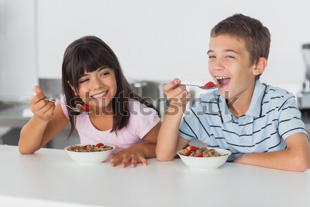 Jolly couple eating fruit lying on their bed  Stock photo © wavebreak_media