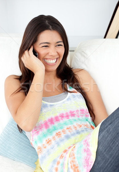 Radiant young woman sitting on sofa at home and phoning  Stock photo © wavebreak_media