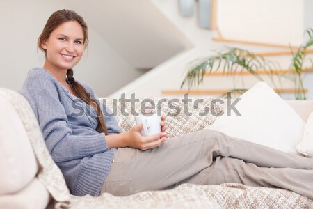 Portrait Of A Woman Buying Online Whilie Lying On A Couch In Her
