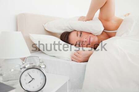 Woman awaken by her alarnclock in her bedroom Stock photo © wavebreak_media