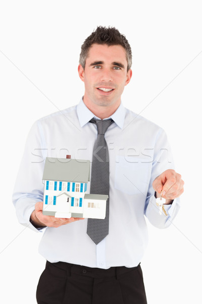 Man holding a key and a miniature house against a white background Stock photo © wavebreak_media