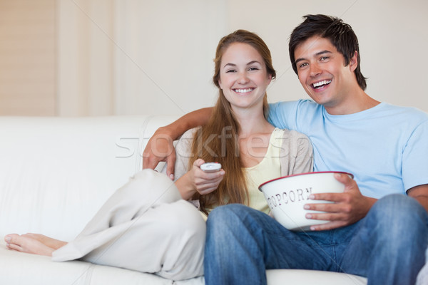 Couple watching television while eating popcorn in their living room Stock photo © wavebreak_media