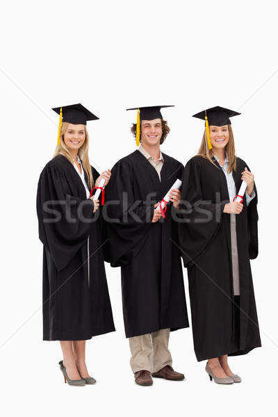 Foto stock: Três · sorridente · estudantes · pós-graduação · robe