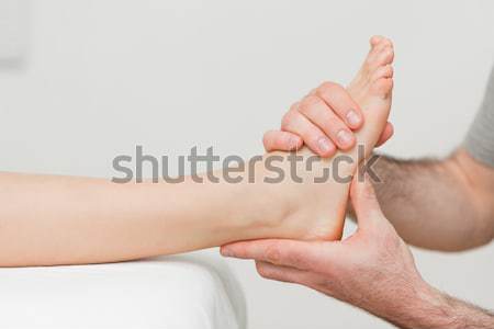 Hands of an osteopath massaging a foot in a room Stock photo © wavebreak_media