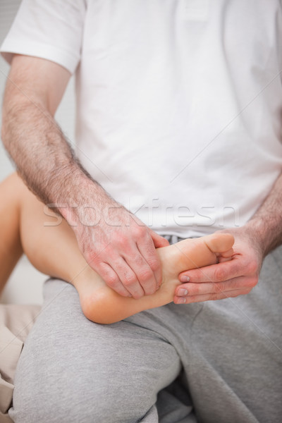 Reflexologist manipulating the sole of the patient in a room Stock photo © wavebreak_media