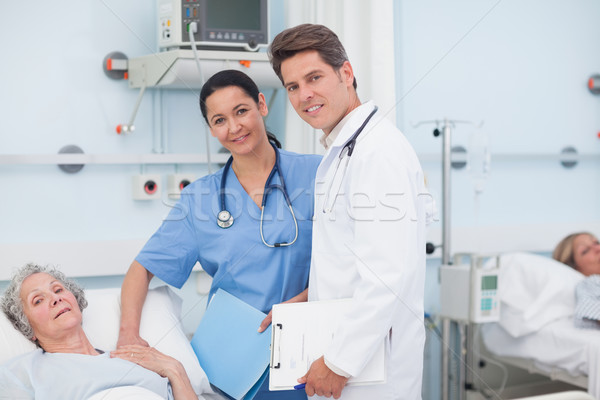 Doctor and nurse next to a patient in hospital ward Stock photo © wavebreak_media